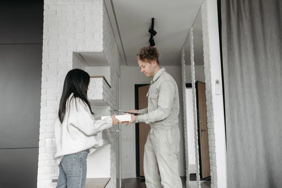 A local service provider handing over paperwork to a customer at the door